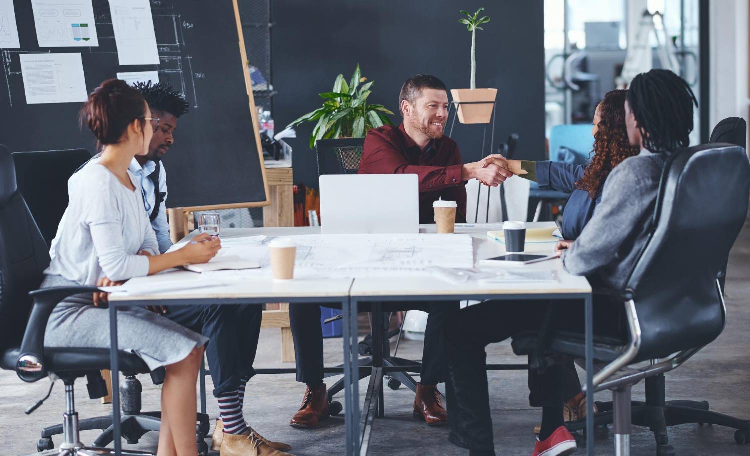 Partners shaking hands across a meeting table